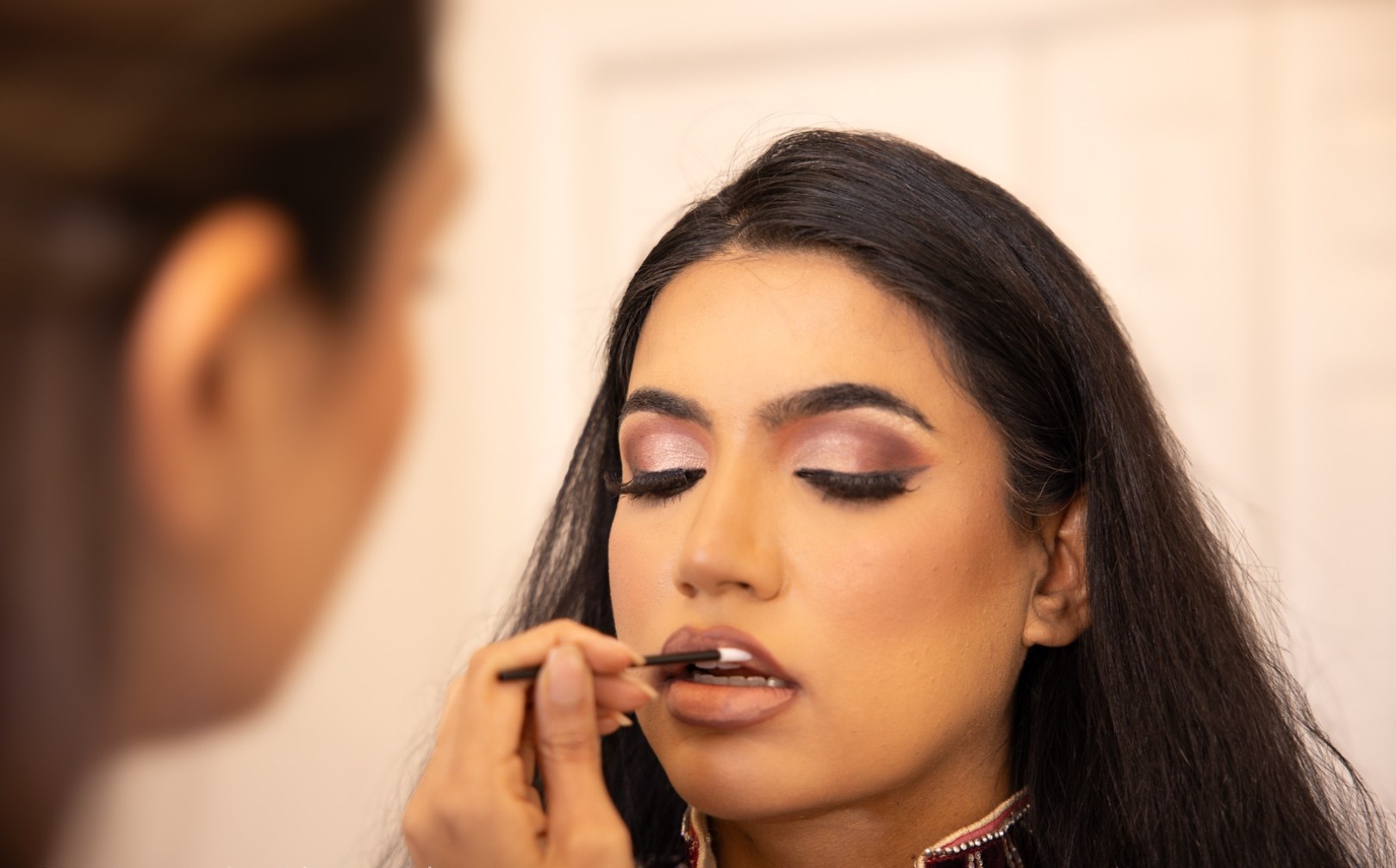 Lips being touched up on a client, close in
